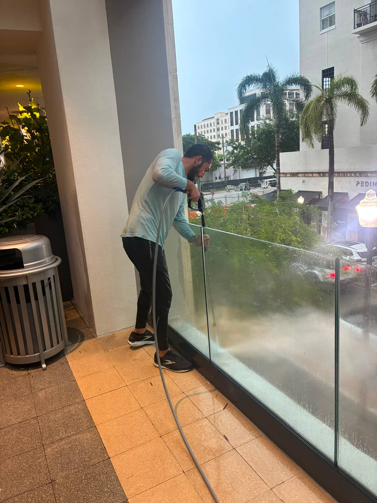 Vista co-founder Jacob Stein pressure-washing the glass railing of a commercial walkway in South Florida