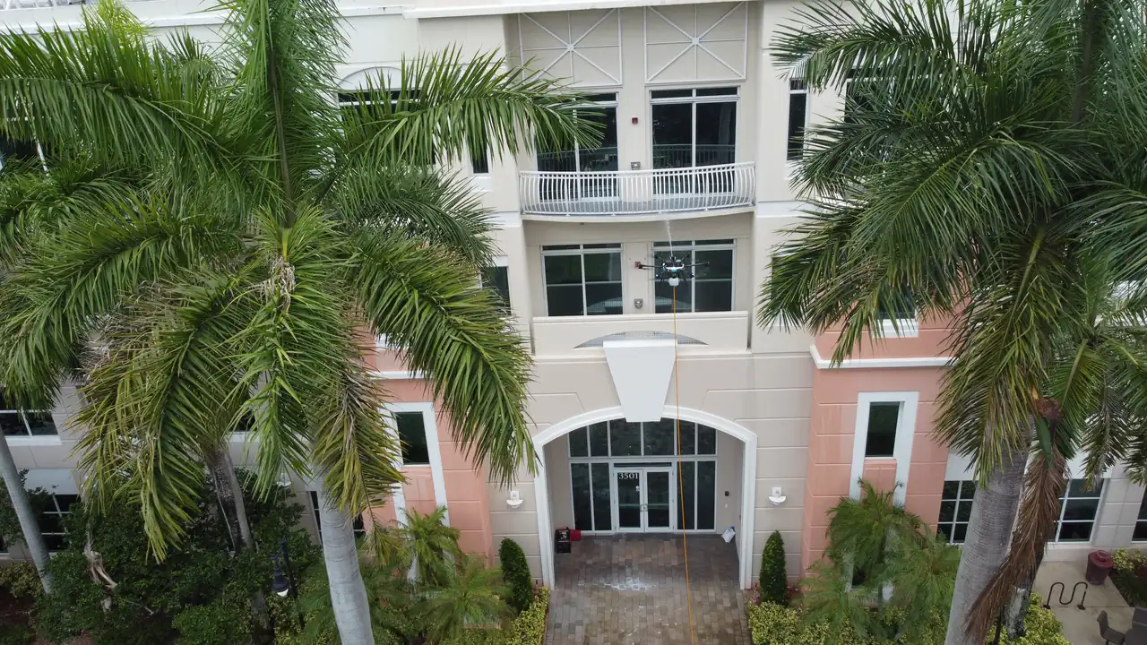 Aerial view of a cleaned Miami commercial building entrance and facade after a drone wash