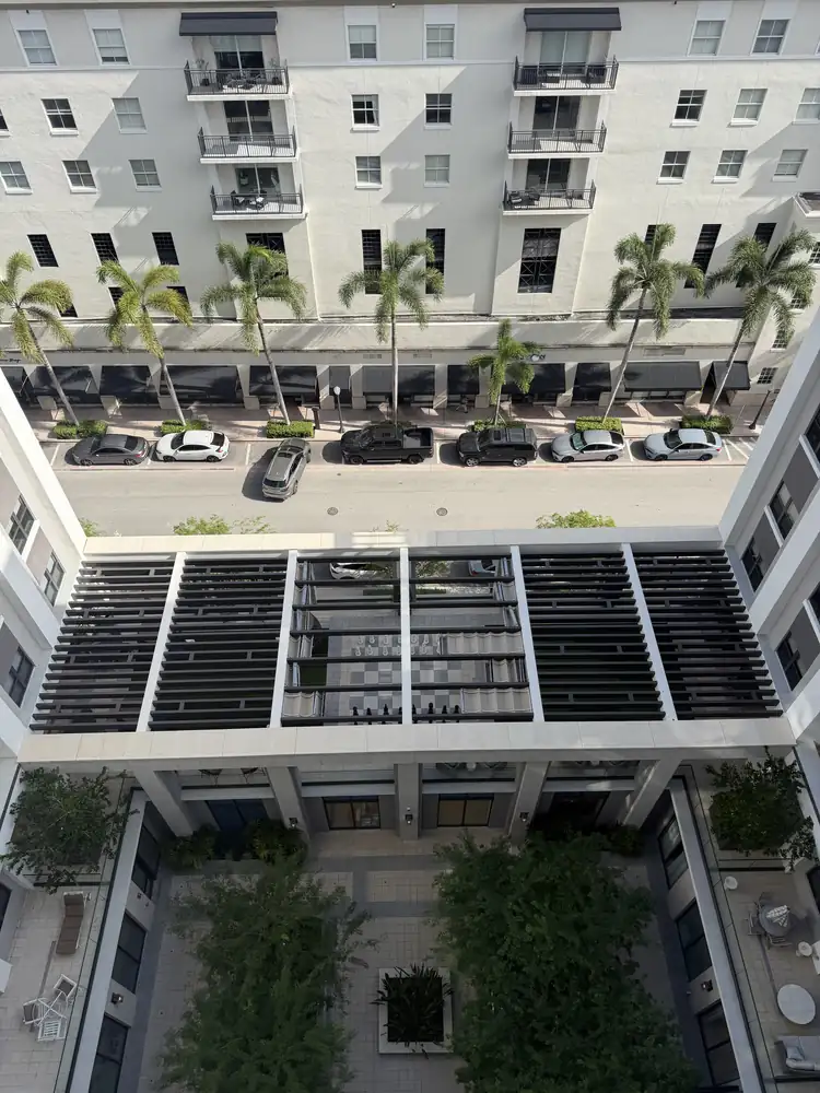 Aerial view of the same Miami mid-rise courtyard after a single-day drone facade wash