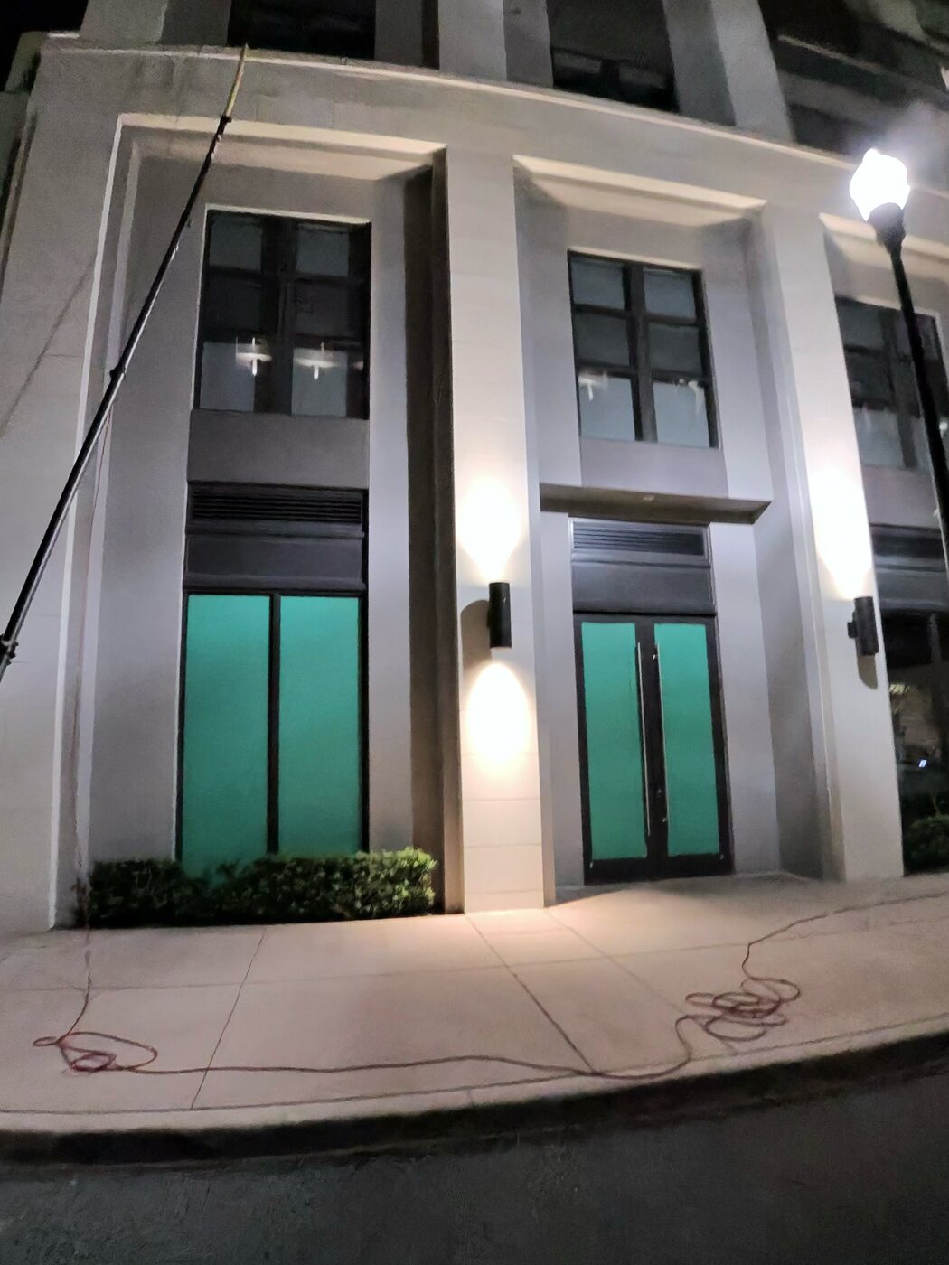 A cleaned, illuminated pedestrian entrance at the Belmont Village high-rise in Coral Gables at night