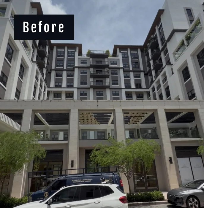 Courtyard facade of Belmont Village in Coral Gables before drone cleaning, dulled stucco above the street