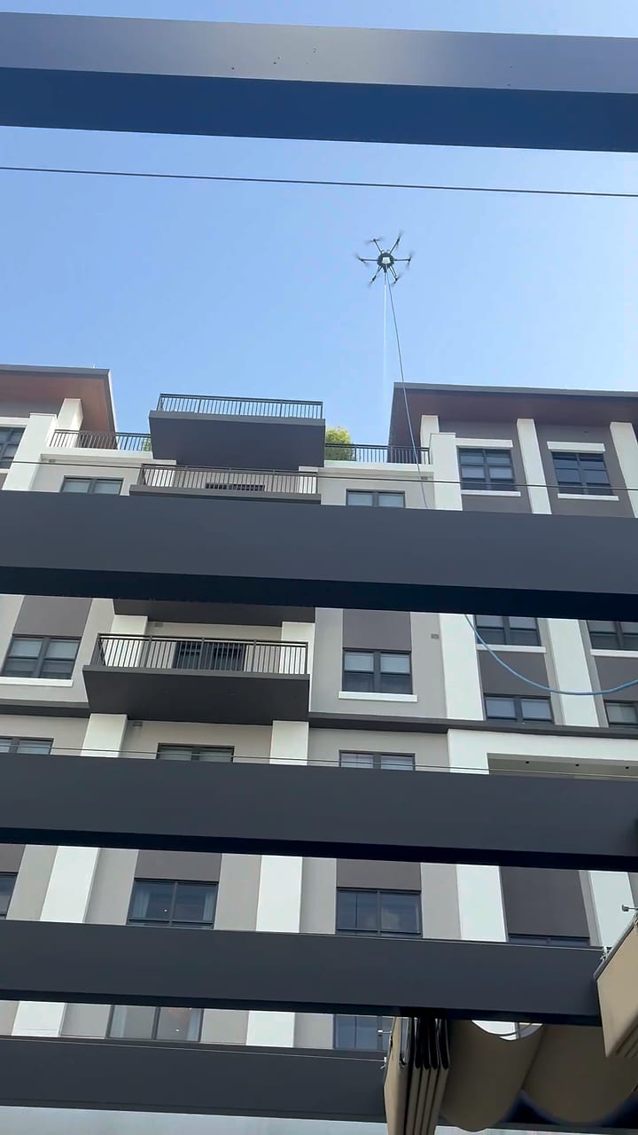 Cleaning drone over a high-rise amenity courtyard and pergola