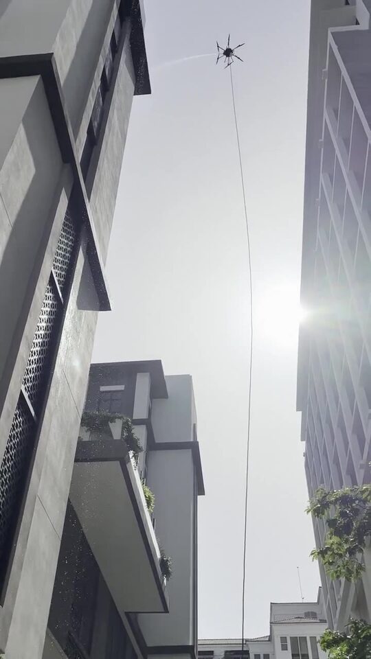 Cleaning drone in flight between the towers