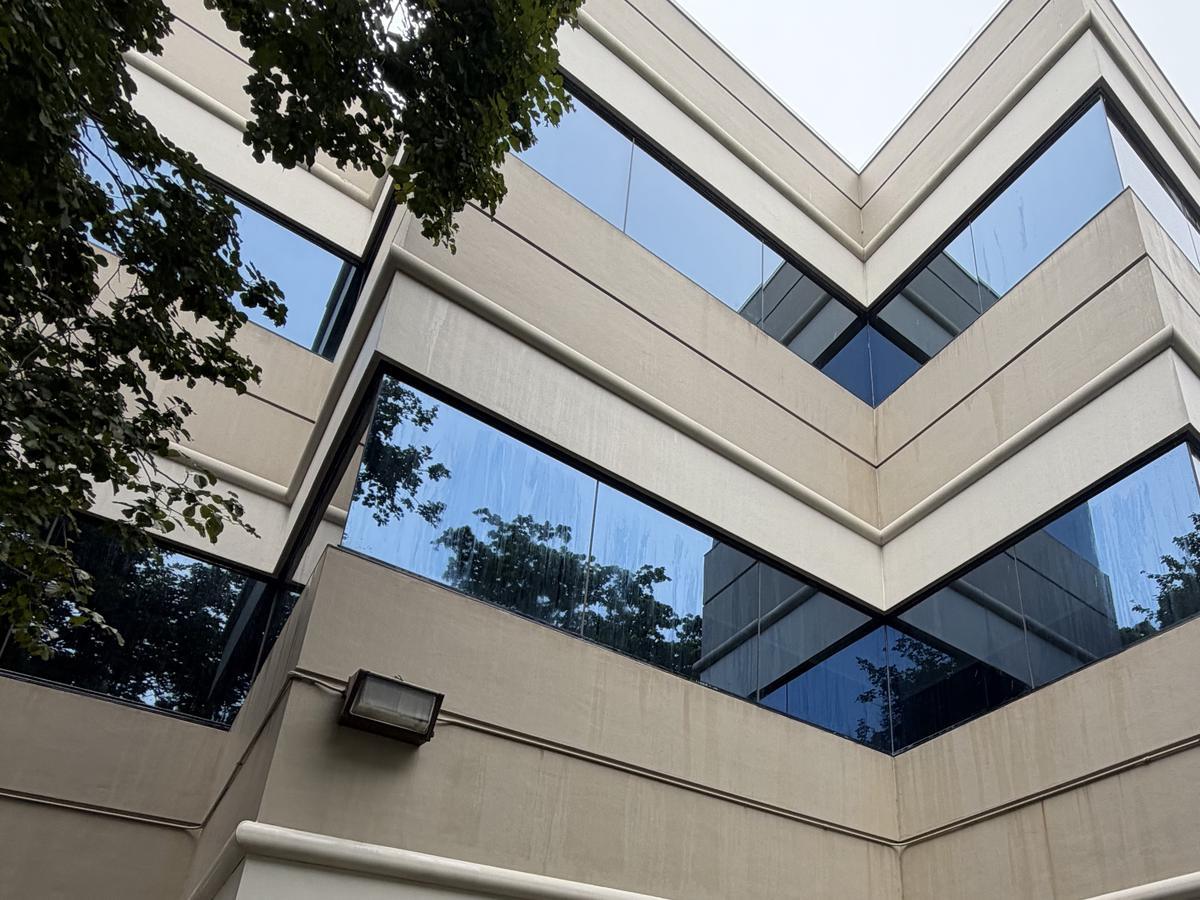 The same panel band and exterior light at Cypress Plaza after cleaning, still damp from the rinse