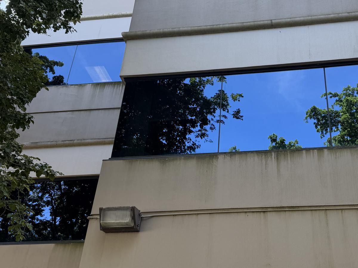 The panel band above an exterior light at Cypress Plaza before cleaning, algae running down from the window ledge