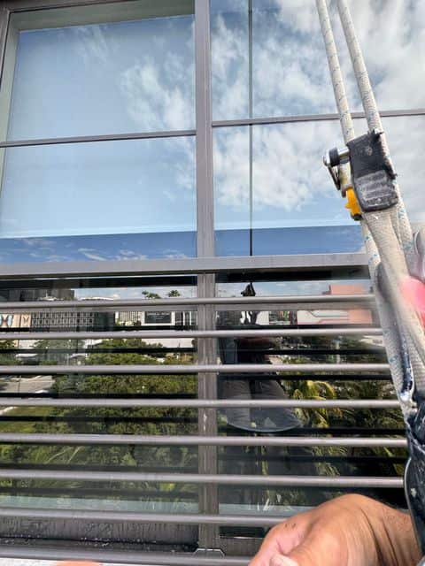 A rope access descender beside a window set behind horizontal railings at Sentral Wynwood